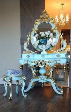 an ornate blue vanity with mirror and stools