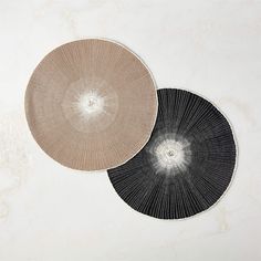 two black and white plates sitting next to each other on top of a marble surface