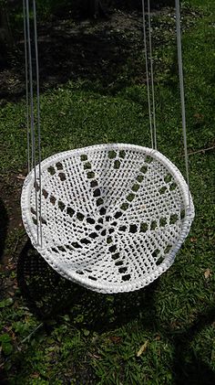 a white hanging chair in the grass