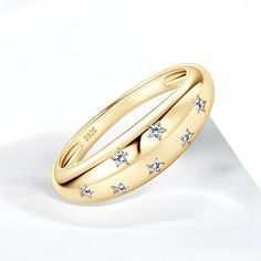 This star-studded dome ring is a stunning statement piece that shines whether worn alone or stacked with others. Crafted from 925 sterling silver or solid gold with moissanite diamonds, it features a thick gold plating and is available in sizes 5-10. Ring Specifications: Material: 925 Sterling Silver , Gold Plated  Gemstone: Moissanite   Care Instructions:  * Protect your jewelry from scratches.  * Avoid exposure to harsh chemicals.  * Store your jewelry away from direct sunlight in a microfiber pouch.  * Clean with warm water and detergent-free soap; thoroughly dry before storing.  * Use a microfiber cloth to polish and maintain the shine of your pieces.  Shipping Details:  We offer free worldwide shipping on all orders. Orders are processed within 3-5 business days (Mon-Fri). Shipping to Gold Dome Ring, Stars Ring, Star Celestial, Ringe Gold, Dome Ring, Stylish Rings, Celestial Jewelry, Ring Moissanite, Star Ring