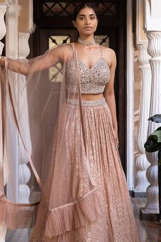 Description:- Rose gold lehenga set, crafted on georgette fabric. Top is accentuated with mirror hand embroidery and lehenga has sequin work all over. It is paired with a matching soft net dupatta. Slight variation in color is possible due to digital photography.Slight variation in color is possible due to digital photography Color Rose Gold Fabric Georgette Occasion Party Wear Wedding Wear Style Lehenga Choli Work Embroidery Please note: Originally stitched in size 32 but can be altered for siz Glamorous Floor-length Georgette Lehenga, Glamorous Floor-length Georgette Choli, Glamorous Festive Georgette Sets, Glamorous Chinon Lehenga For Festive Season, Glamorous Sets With Mirror Work In Chinon, Glamorous Chinon Sets With Mirror Work, Glamorous Georgette Anarkali Set With Zari Work, Glamorous Designer Lehenga For Eid, Glamorous Chinon Lehenga For Wedding