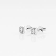 Emerald cut lab grown diamond stud earrings. A popular European style, these diamonds are wrapped in a high polished bezel setting. Modern White Gold Earrings With Bezel Setting, Modern Diamond Earrings With Bezel Setting, Fine Jewelry Diamond White Diamond Earrings With Bezel Setting, Formal White Gold Diamond Earrings With Bezel Setting, Anniversary Bezel Set Diamond Earrings, Anniversary Fine Jewelry Diamond Earrings With Bezel Setting, Anniversary Diamond Earrings With Bezel Setting, Gift White Diamond Earrings With Bezel Setting, Gift White Bezel Set Diamond Earrings