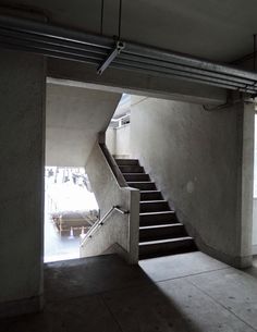 there is a staircase going up to the second floor in this building with concrete walls