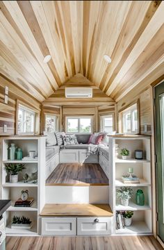 the interior of a tiny home with wood floors and white walls, built in shelving