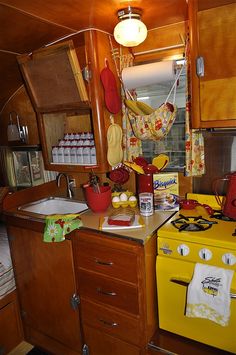 an old fashioned kitchen with yellow stove and wooden cabinetry in the back ground area