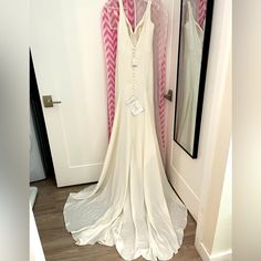 a white dress hanging in front of a mirror