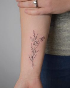 a woman's arm with a small flower tattoo on the left side of her wrist