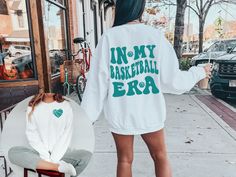 Celebrate your passion for basketball with this stylish and comfortable sweatshirt. The phrase 'In My Basketball Era' boldly adorns this garment, symbolizing the dedication, skill, and love for the game. 🔥 Made with cozy fabric, this sweatshirt offers both style and comfort on and off the court. Whether you're shooting hoops, practicing drills, or simply lounging after a game, this sweatshirt is the perfect companion for every basketball enthusiast. 🎁 Looking for the perfect gift for a basketball player, coach, or someone who lives and breathes the game? Our 'In My Basketball Era' sweatshirt is an ideal choice to celebrate their love for the sport and dedication to the game. 🏆🌈 Available in various sizes and colors to match individual tastes, this sweatshirt is a thoughtful and stylish Softball Sweatshirt, Volleyball Coach Gifts, Volleyball Sweatshirts, Cheer Coach Gifts, Dance Sweatshirt, Gymnastics Mom, Girls Basketball, Cheerleading Gifts, Cheer Coaches