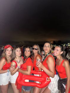 a group of young women standing next to each other wearing red shirts and white shorts