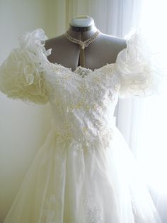 a white wedding dress on display in front of a window