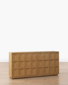 a large wooden dresser sitting on top of a hard wood floor next to a white wall