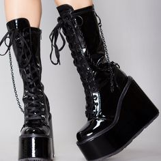 Bring In A New Era Of Fear With The Dark Age Platform Boots From Demonia. These Sinful Festival Boots Feature A Black Vegan Patent Leather Upper With Lace Up Front, Wedge Heel, O Ring And Chain Accents, And Interior Zipper Closure. Throw On These Heinously Cute Boots And Let Chaos Reign. Dark Age Platform Boots 5 1/2"" Wedge Platform Vegan Patent Leather Lace-Up Front Stretch Knee High Boot Removable Metal Chain Detail Inside Metal Zip Black Edgy High Ankle Patent Leather Platform Boots, Edgy Patent Leather High Ankle Platform Boots, Black High Heel Lace-up Boots, Black High-top Wedge Boots With Chunky Platform, Black Lace-up Wedge Boots With Chunky Platform, Black Ankle-high Wedge Boots For Streetwear, Black Lace-up Chunky Platform Wedge Boots, High-top Patent Leather Platform Boots For Party, High-top Platform Patent Leather Boots