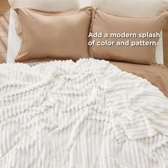 a bed covered in white blankets and pillows with the words, add a modern splash of color and pattern