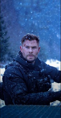 a man standing in the snow with his arms crossed