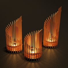 three lit candles sitting on top of a table next to each other in front of a black background