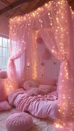 a pink bedroom with fairy lights on the walls and bed in the center, along with fluffy pillows