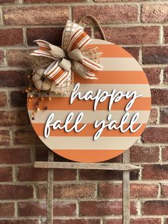 a happy fall y'all sign on a brick wall