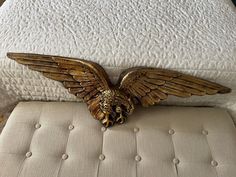 a golden eagle statue sitting on top of a bed