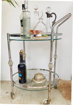 a bar cart with liquor bottles on it and a clochel in the middle