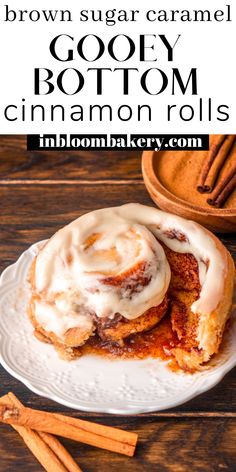 cinnamon rolls on a white plate with cinnamon sticks and cinnamon sugar caramel in the background