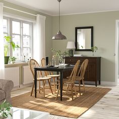 a dining room table with four chairs and a mirror on the wall in front of it