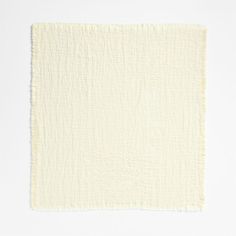 a white square rug with fringes on the edges and bottom corner, against a white background