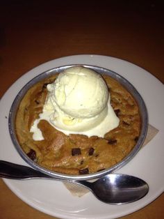 a waffle topped with ice cream on top of a white plate next to a spoon