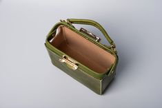 "*DOCTOR BAG'S HANDMADE VIDEO* https://youtu.be/QpdhSCjh2BM Product Description * Material: vegetable tanned leather * Color: Hand-dyeing olive green * Flap over entry with buckle closure ,a rounded projection on the, please press it up to open the flap * 0.75\" wide leather shoulder strap : 110cm * Sewn by hand; * Size: 140mm (H) x 170mm (W) x 70mm (D) / 5.5\" x 6.7\" x 2.7\" Please first look at the production process of our product. 1. The vegetable tanned leather is made in Italy: Vegetable Green Rectangular Bucket Bag For Office, Green Rectangular Bucket Bag With Detachable Handle, Green Leather Bag With Mobile Phone Pocket, Green Leather Mobile Phone Bag, Green Handheld Leather Bag, Leather Phone Bag With Removable Pouch, Rectangular Leather Bucket Bag, Leather Square Phone Bag For Daily Use, Square Leather Phone Bag For Office