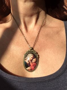 Beautiful pendant of the Virgin Mary and baby Jesus. The pendant is approx. 2,2 x1,6 inch (5,5 x 4 cm) and is set in a leadfree antique brass setting. The necklace is a leadfree antique brass chain (length approx. 42cm). Due to the shape of the glass cabochon the light is reflected, so the real pendant is much more beautiful than the picture. The pendant is delivered in a nice gift pouch. Please follow me on Pinterest and Instagram! Vintage Jewelry For Mother's Day Personalized Gift, Vintage Necklace For Birthday And Mother's Day, Artistic Necklaces For Mother's Day Gift, Vintage Round Necklace As Gift For Mom, Handmade Vintage Necklace For Personalized Gift, Handmade Vintage Necklaces For Personalized Gifts, Vintage Handmade Necklaces For Personalized Gifts, Vintage Adjustable Necklace For Mother's Day, Personalized Jewelry For Mother's Day Collectible