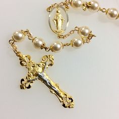 This is a jewelry quality Catholic rosary. Features: Beautiful 8mm Swarovski cream glass pearls. 2" Gold Plated Two-Tone Pewter Crucifix. 1" Gold Plated Two-Tone Pewter Center Piece. Gold base metal bead caps and chain. Packaged in a gold foil gift box. Not finding the rosary you would like? Custom, made to order rosaries are available. I have access to an endless choice of beads, Crucifixes and center pieces. I specialize in special occasion pieces perfect for First Communion, Confirmation, Wed Elegant Pearl Rosary With 8mm Beads, Elegant Rosary With 8mm Beads And Crucifix, Elegant Pearl Rosary With Round Beads, Elegant Pearl Beaded Rosary, Elegant Pearl White Pearl Rosary, Metal Bead, Catholic Rosary, The Rosary, Rosary Catholic