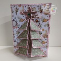 a christmas card with a tree made out of folded paper and some other things on it