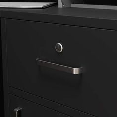 a black filing cabinet with two drawers and a computer monitor on the top one drawer