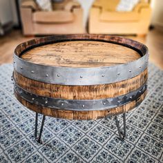 a wooden barrel coffee table sitting on top of a rug