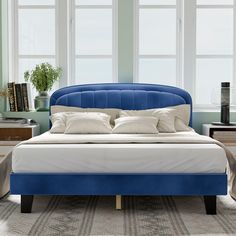 a bed with blue headboard and white pillows