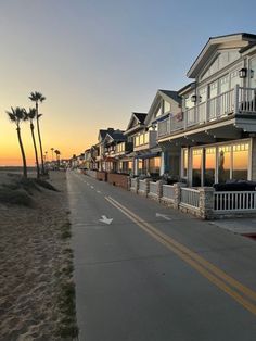 a row of houses on the beach at sunset