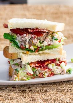 two sandwiches stacked on top of each other with meat and veggies in them