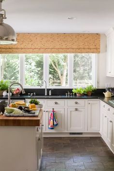 a kitchen filled with lots of white cabinets and counter top space next to a window