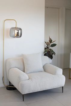 a white chair sitting next to a potted plant