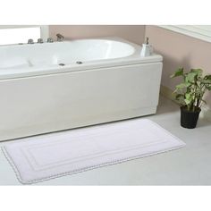 a white bath tub sitting next to a potted plant