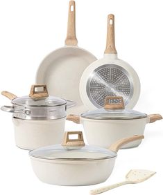 an assortment of ceramic cookware including pots and pans with wooden handles, on white background