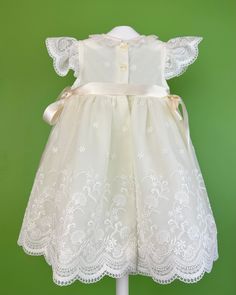 An adorable and delicate off-white dress for baby girls to wear on a special day. It is made with an embroidered french tulle. It has buttons on the back for closure and comes with a matching bonnet. Made in Spain Inside: 65% polyester 35% cotton Dry Clean Final sale, no exchanges nor returns are accepted Cream Dress With Ruffles For First Communion, Embroidered Tulle Dress For Ceremonies, Cream Ruffled Baptism Dress For Dress-up, Cream Lace Trim Princess Dress For Wedding, Fitted Cream Princess Dress With Lace Trim, Cream Princess Dress With Lace Trim For Wedding, Cream Wedding Princess Dress With Lace Trim, White Baptism Dress With Lace Bodice For Dress-up, Baptism Dress With Lace Bodice And Organza Material