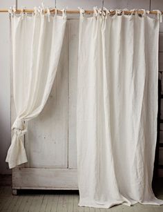 a white curtain hanging on the side of a wooden door