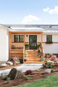 a small white house with steps leading up to the front door and covered porch area