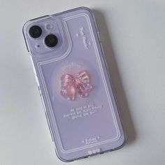 an iphone case with a pink bow on it sitting on a white surface next to a pair of glasses