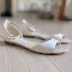 a pair of white shoes sitting on top of a wooden floor