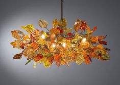 a chandelier with many different colored leaves hanging from it's center point