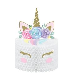 a white cake topped with a unicorn's face and flowers on top of it