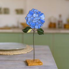 a blue flower sitting on top of a wooden table