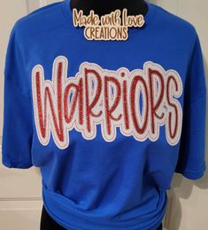 This listing is for a WARRIORS unisex shirt. This embroidered shirt comes in colors/fabric prints of your choice.  THIS LISTING IS ONLY FOR THE MASCOT SHIRT PICTURED AND LISTED ABOVE  OTHER MASCOTS ARE AVAILABLE PLEASE MESSAGE US OR BROWS OUR SHOP. IF THIS SHIRT IS ORDERED AND YOU PUT ANOTHER MASCOT NAME IT WILL BE CANCELLED. Feel free to request color changes. If you have no special requests, your design will resemble the first picture in the listing as closely as possible. Some fabrics in the applique design may differ slightly depending on availability of fabric. We use a mix of HTV glitter or glitter fabric and sequins on our designs.  We use unisex Gildan brand sweatshirts, Gildan softstyle t-shirt and Gildan long sleeve shirt for most orders we also use other brands when needed.  We High School Spirit Wear, Brand Sweatshirts, School Shirt Designs, Mascot Shirt, School Spirit Wear, Warriors Shirt, Spirit Shirts, Fabric Prints, Team Shirt