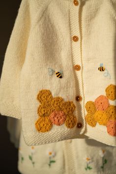 a teddy bear sweater is hanging on a clothesline with bees and honeybees